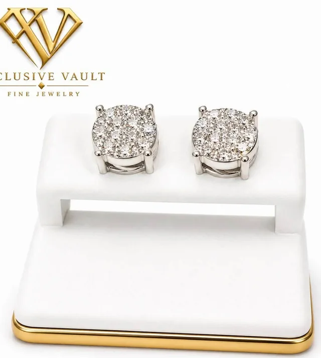 A pair of diamond cluster stud earrings on a white Xclusive Vault display.