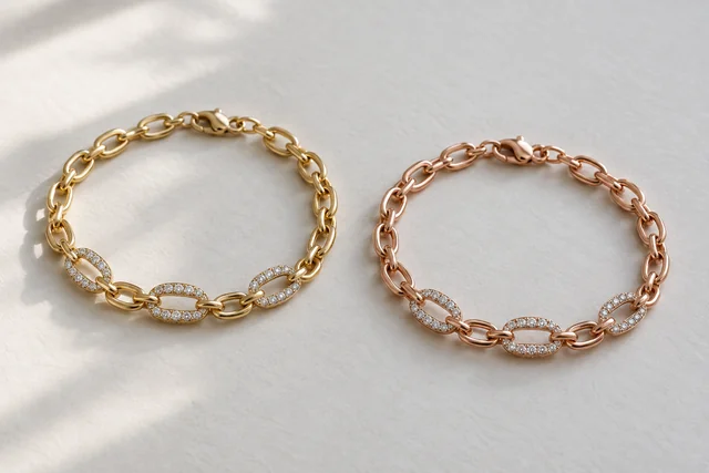 Yellow-gold and rose-gold oval-link bracelets with diamond-set links, arranged side by side on pale paper.