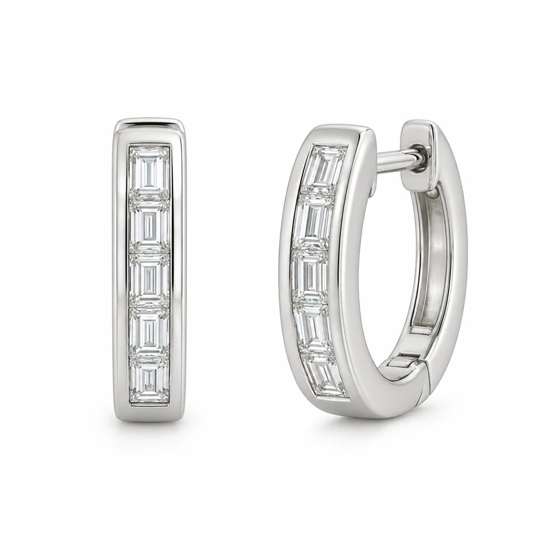 A pair of white-gold rectangular huggie hoops with channel-set baguette diamonds and complete hinged silhouettes on pure white.