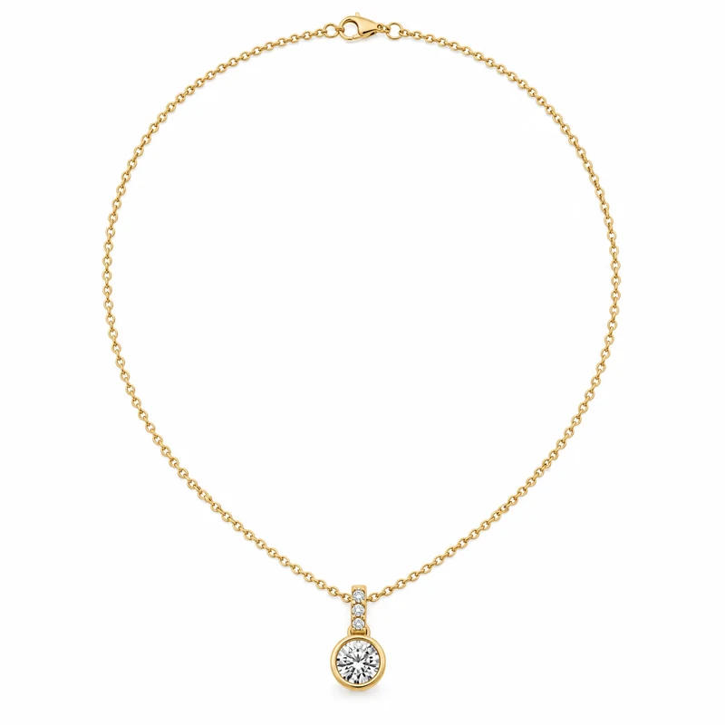 A round brilliant diamond in a slim yellow-gold bezel pendant, with its complete delicate chain and clasp on pure white.