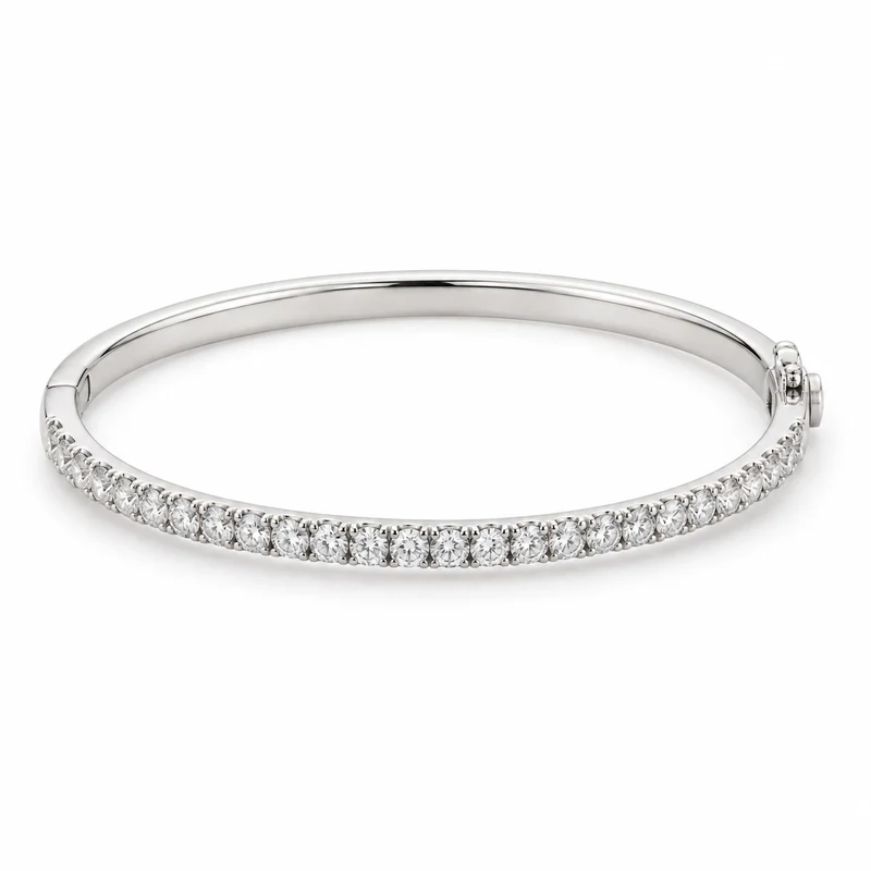 A complete white-gold oval bangle with round diamonds across the front and a discreet hinged clasp, on pure white.