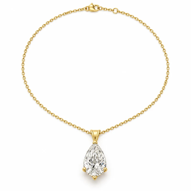 Yellow-gold pear diamond pendant with its fine chain laid in a complete loop on pure white.